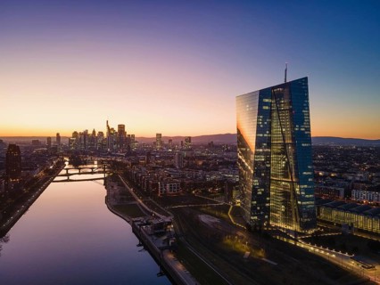 The lights in the offices of the European Central Bank (ECB) and the Frankfurt skyline glow in the
