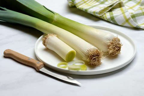Leek, leek sticks on plate with knife, leek