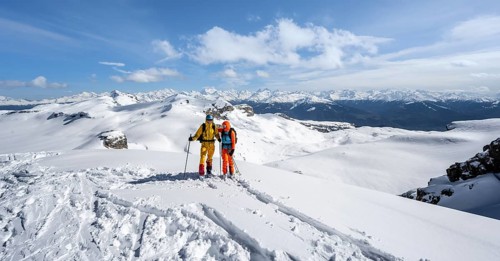 Couple, two ski tourers at the summit Wisshore with mountain panorama, snowy mountain landscape,