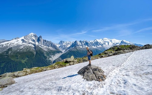 Mountaineer on a hiking trail in front of a mountain landscape, view of mountain peaks Aiguille