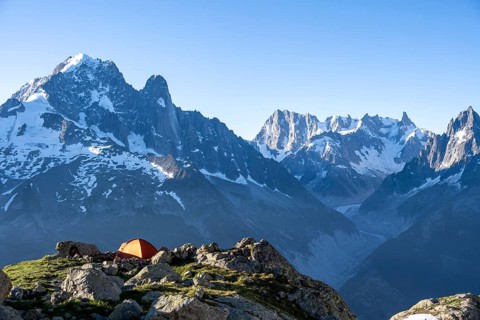 Red tent in front of a mountain panorama, mountain landscape in the morning light, mountain peaks