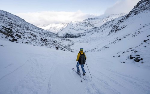 Skiers skiing downhill in a snow-covered mountain landscape in the Madritschtal valley, Ortler