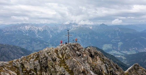 Aerial view, hiker on the Raudenspitze with summit cross, Carnic High Trail, Carnic Main Ridge,