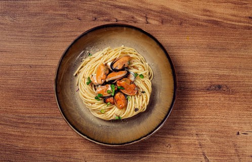 Spaghetti with mussels, without shell, pasta with peeled mussels, in carbonara sauce, micro-greens,
