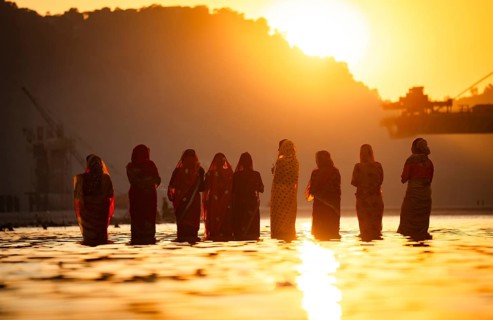 Hindu devotees perform rituals as they offer prayers to the Sun god in the bank of Brahmaputra