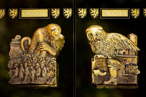 Door handles on the glass doors of the town hall with motifs from the history of the city of