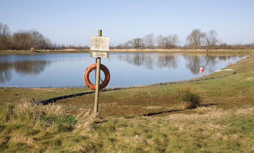 Orange life saving ring by irrigation water reservoir, Sutton, Suffolk, England, United Kingdom,