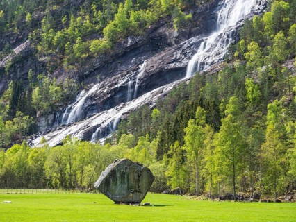Waterfall Vidfossen, single large rock Oddmundsteinen, south of town Odda at fjord Sørfjord, branch