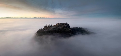Aerial panorama of the Hegau volcano Hohentwiel with the upper fortress ruins in front of sunrise,