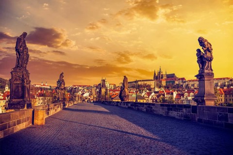 Charles bridge with statues and Prague castle in the early morning on sunrise. Prague, Czech