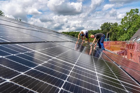 Installation of solar modules on the roof of a barn on a farm, over 210 photovoltaic modules are