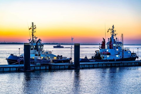 The tugboat pier, harbour tugs waiting for their next assignment, at the New Harbour, sunset over