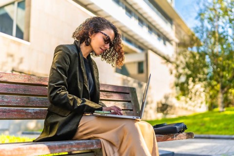 Profile of a beauty young arab businesswoman in casual clothes and sunglasses working with laptop