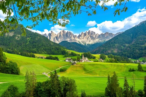 Framing the iconic santa maddalena church, green meadows and trees highlight the breathtaking