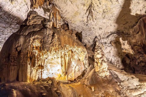 Large stalactites and stalagmites creating geological formations inside postojna cave, a famous