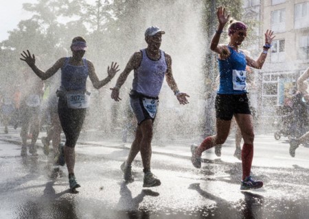 The participants of the Berlin Marathon are cooled down with a water shower in the Schöneberg