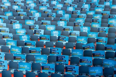 Assembly hall, deserted with many empty chairs and posters with the inscription UNSER KANNZLER.
