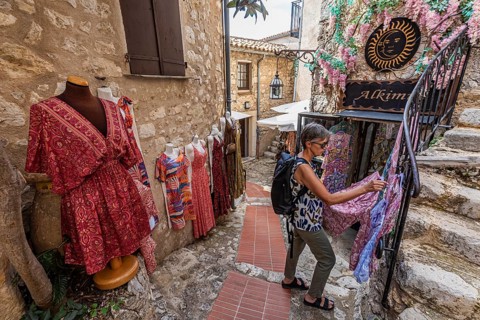 Women's clothing, woman, 62 y., in front of Boutique Alkimia in the mountain village Èze Village on