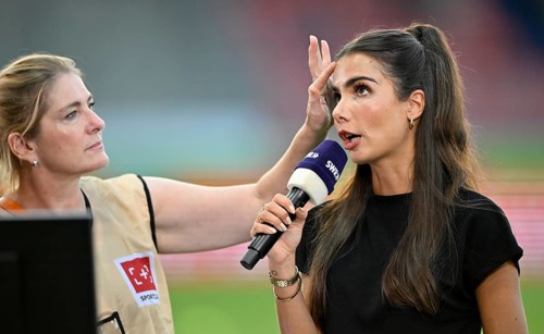 Make-up artist fixes the hair of TV presenter Lea Wagner, in an interview, microphone, mike, logo,