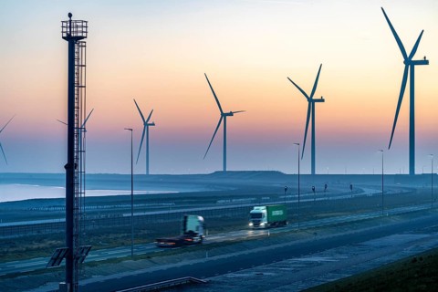 Lorry on the road to Euromax Terminal Rotterdam, ENECO wind farm on the dike around the port of