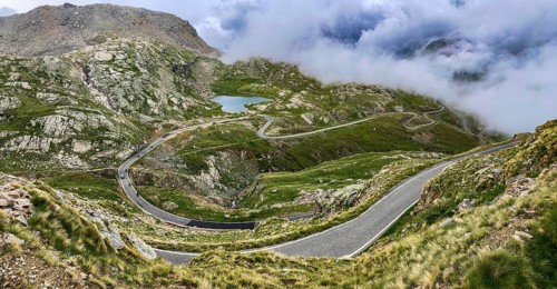 In the foreground a winding pass road to the Colle del Col de Nivolet pass, in the background a