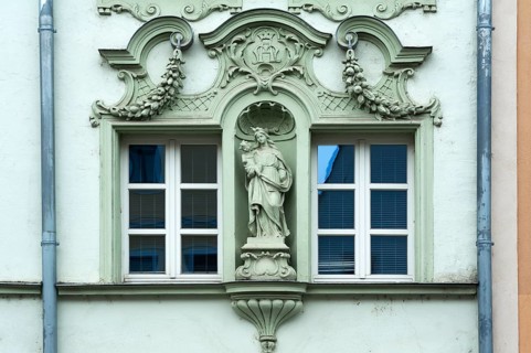 Window framed with figures of saints on a historic façade from 1895, of a former liqueur