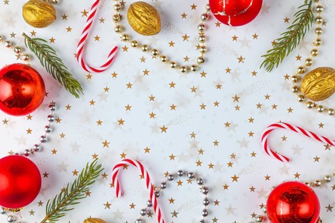 Frame made of Christmas decorations, fir branches, baubles, nuts on a white background with golden