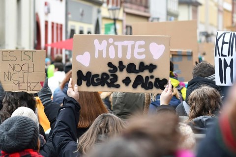 Heidelberg, Germany - February 12th 2025: Person holding up sign saying 'Middle insteaf of Merz and