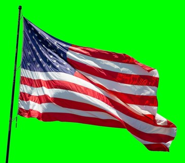 American flag waving in the wind on a flag pole over a green screen