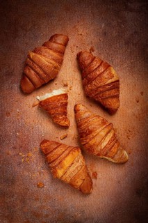 Fresh croissants, breakfast, top view, on the table, brown background, no people