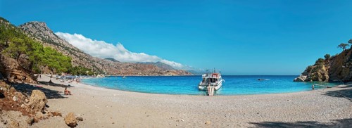 Coastal scene with a boat on Apella beach and blue sky, Apella beach, Karpathos, Greece, Europe