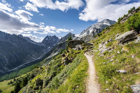 Hiking trail through picturesque mountain landscape near Arolla, behind mountain peak Mont Collon,