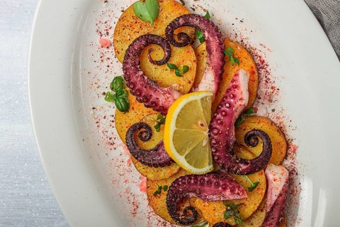 Octopus with potatoes and spices, on a light plate, top view, no people, homemade, close-up
