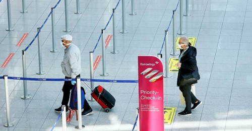 Passengers wearing face masks at the Eurowings check-in counter at Düsseldorf Airport during the