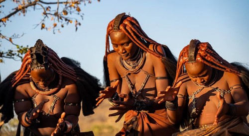 Traditional Himba woman clapping, music and dance, portraits, in the evening light, near Opuwo,