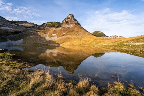 Lake Augstsee and the Atterkogel mountain on the Loser. Autumn, good weather, blue sky. Reflection.