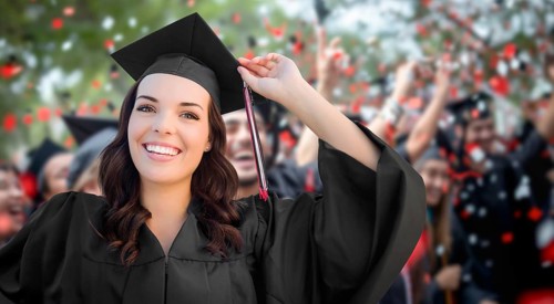 Young female graduate celebrating her graduation with her fellow classmates outdoors