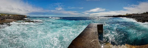 Former whale towing facility in stormy sea with waves and clouds in the sky, whale station and