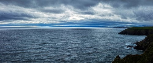 Gloomy panorama of the coast under a heavy, cloudy sky, Waterford Coast