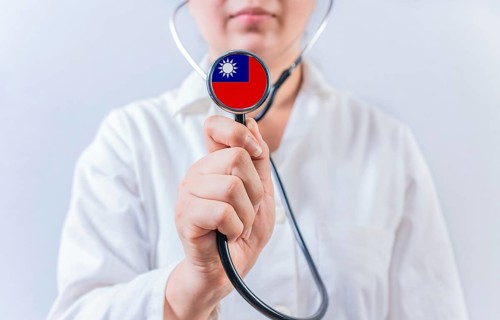 Female doctor holding stethoscope with Taiwan flag. National health system of Taiwan