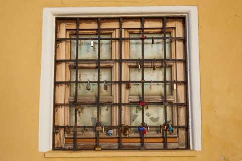 A shuttered window with bars in a yellow wall, harbour area, Rhodes Town, Rhodes, Dodecanese, Greek