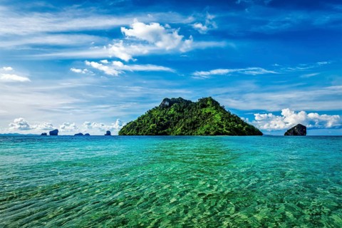 Vacation holidays concept background, tropical island and long-tail boat in sea. Thailand