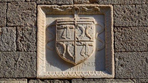 Small square stone relief with a coat of arms and a partially legible inscription, Knights' Street,