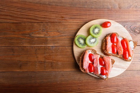 Smoked salmon sandwiches with butter on wooden background. cherry tomatoes. top view, copy space