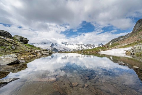 Picturesque mountain landscape with mountain lake, mountains and glaciers reflected in the
