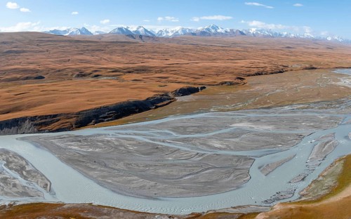 Aerial view, Burkhan mountain valley with meandering river, barren dramatic mountain landscape,