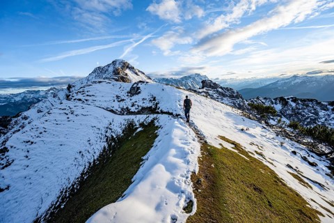 Mountaineer on hiking trail, mountain landscape with snow in autumn, summit and ridge of the