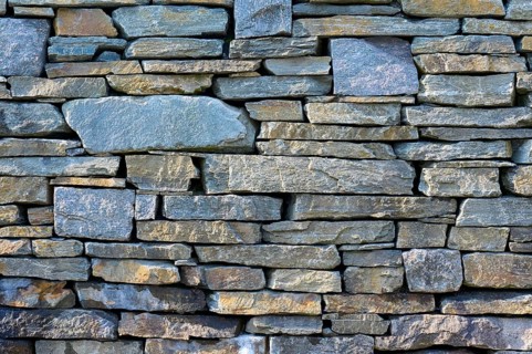 Large, irregular natural stones in various shades of grey form a rustic stone wall, Bergen,