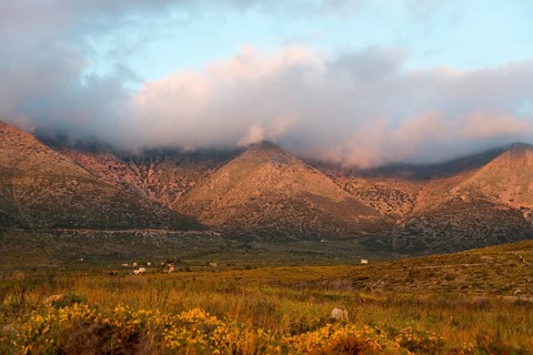 Mountain landscape at dusk with clouds enveloping the peaks in a tranquil rural setting, Itylo,