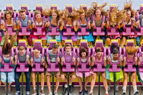 Boys and girls swinging with blowing hair in giant swing Top Spin Fresh, swing, ride on the Wies'n,